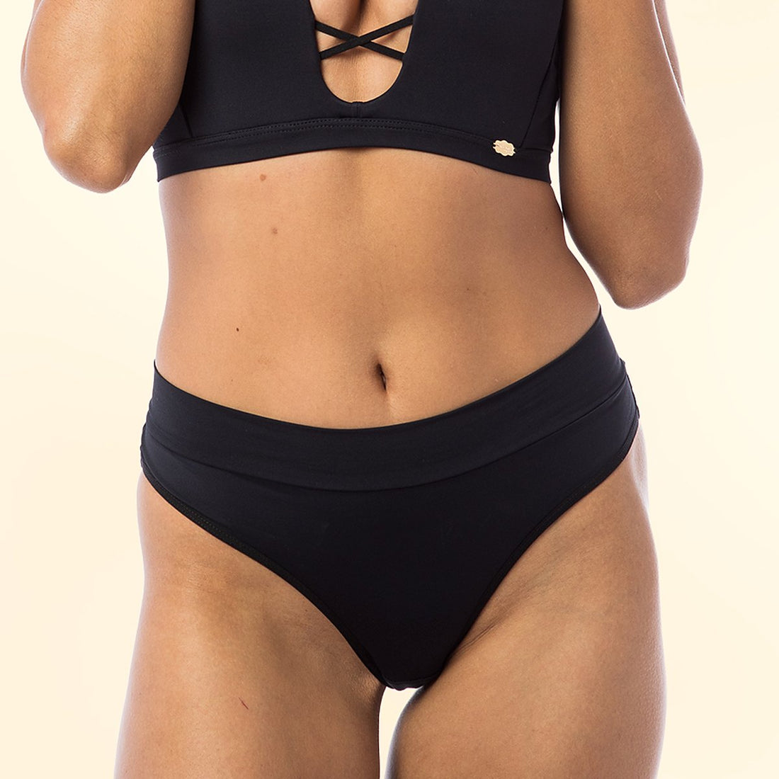 Model wearing the Solta Aurora Brazilian knicker in black, showing the wide waistband and the high-cut leg opening